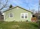 Charming exterior featuring sage green siding, white trim and a small porch with wooden rails and address numbers at 1801 Bauer Rd, Indianapolis, IN 46218
