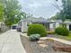 View of the side of the house with a long driveway and detached garage and tidy yard at 1844 N Riley Ave, Indianapolis, IN 46218