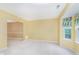 Bright, neutrally-carpeted living room with yellow walls, bay window, and entrance to another room at 19061 Fairfield Blvd, Noblesville, IN 46060