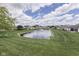 Enjoy this view of the community pond, surrounded by green grass and mature trees at 2025 Flamingo Way, Franklin, IN 46131
