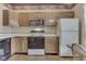 Traditional kitchen with light wood cabinets, white appliances, and laminate flooring in a pattern at 2025 Flamingo Way, Franklin, IN 46131
