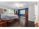 Spacious bedroom with a ceiling fan, hardwood floors, and a sliding glass door to the backyard at 2027 Round Barn Ct, Anderson, IN 46017