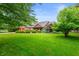 Traditional ranch home with green lawn, mature trees, and brick exterior at 2027 Round Barn Ct, Anderson, IN 46017