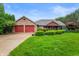 Charming brick ranch home with attached two-car garage and well-manicured lawn at 2027 Round Barn Ct, Anderson, IN 46017
