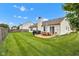 Spacious backyard with lush green grass, a cozy patio, and outdoor dining set under a clear blue sky at 2163 Bradford Trace Blvd, Indianapolis, IN 46229