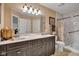 Bathroom with a large vanity with double sinks, a shower, and a decorative mirror at 2163 Bradford Trace Blvd, Indianapolis, IN 46229