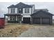 Striking two-story home with black and white accents, a covered porch, and a three-car garage at 2271 Oakmont Dr, Plainfield, IN 46168