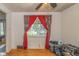 Bedroom with hardwood floors, red curtains, and a view of the outdoors at 2445 S Bolton Ave, Indianapolis, IN 46203
