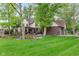 Spacious backyard with a lush green lawn, patio seating area, and beautiful landscaping around the house at 246 Westchester Blvd, Noblesville, IN 46062