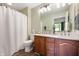 Bathroom featuring dual sinks, wood cabinets, and a shower-tub combination with patterned curtain at 2717 W Long Meadow Ln, Muncie, IN 47304