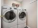 Modern laundry room featuring front load washer and dryer on pedestals with a wire rack above at 2717 W Long Meadow Ln, Muncie, IN 47304