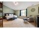 Serene main bedroom featuring a large window, neutral carpet, and a sitting area with a chair and ottoman at 2717 W Long Meadow Ln, Muncie, IN 47304