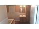 Neutral bathroom featuring a tub, a wooden vanity, and built-in cabinet with matching brown ceramic tile flooring at 3107 N 100 W, Shelbyville, IN 46176