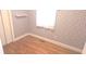 A quaint room featuring hardwood floors, a built-in shelf, and pink floral wallpaper at 3107 N 100 W, Shelbyville, IN 46176