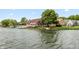 Waterfront home featuring a large deck, well-maintained lawn, and a private boat dock on the lake at 3403 Island Way, Indianapolis, IN 46214