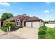 Inviting red-sided house with a two-car garage and well-maintained landscaping near a picturesque lake at 3403 Island Way, Indianapolis, IN 46214