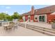 Back exterior of red home with large deck that features outdoor furniture, stairs, and sliding glass doors at 3403 Island Way, Indianapolis, IN 46214