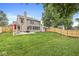 Expansive backyard featuring a patio, privacy fence, lush lawn, and mature trees at 3803 Churchman Woods Blvd, Indianapolis, IN 46203