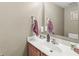 A clean powder room with a white counter and cherry wood vanity at 3803 Churchman Woods Blvd, Indianapolis, IN 46203