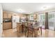 Bright dining area featuring wood cabinets, floors, island, and a sliding door to the outdoor space at 3803 Churchman Woods Blvd, Indianapolis, IN 46203