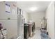 Modern laundry room featuring a washer, dryer and utility sink, with white and tan walls at 3803 Churchman Woods Blvd, Indianapolis, IN 46203