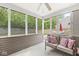 Enclosed patio with views of the fenced in backyard, couch, pillows, and a ceiling fan at 3803 Churchman Woods Blvd, Indianapolis, IN 46203