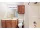 Bathroom with wooden cabinets, mirror, sink, toilet and shower, providing essential amenities at 3916 Jekyll Ct, Indianapolis, IN 46237