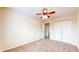This carpeted bedroom has neutral walls, a ceiling fan, and double-door closet with an open doorway at 3916 Jekyll Ct, Indianapolis, IN 46237
