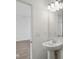 A bright bathroom features a pedestal sink, large mirror, and stylish lighting at 3947 Wren Dr, Brownsburg, IN 46112