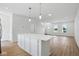 Bright kitchen with a large center island, hardwood floors and modern lighting at 3947 Wren Dr, Brownsburg, IN 46112