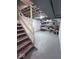 Unfinished basement with painted floor, exposed ceiling, a support post, and wooden steps offers potential for customization at 4040 Carrollton Ave, Indianapolis, IN 46205