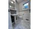 Charming powder room with pedestal sink, wood accent wall, and marble-look flooring at 4040 Carrollton Ave, Indianapolis, IN 46205