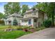 Charming two-story home with a well-maintained lawn, mature trees, and colorful flowerbeds at 4040 Carrollton Ave, Indianapolis, IN 46205