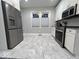 Bright kitchen with stainless steel appliances, white cabinets, and marble-look floors at 4040 Carrollton Ave, Indianapolis, IN 46205