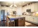 Bright kitchen features a granite island with seating, modern stainless appliances, and decorative shelving at 4420 Hickory Ridge Blvd, Greenwood, IN 46143