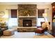 Living room featuring a stone fireplace, windows with shades, and an ottoman at 4420 Hickory Ridge Blvd, Greenwood, IN 46143