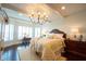 This main bedroom offers great natural light, a decorative chandelier, and hardwood floors at 4420 Hickory Ridge Blvd, Greenwood, IN 46143