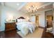 This beautiful main bedroom has a decorative chandelier, hardwood floors, and an attached bathroom at 4420 Hickory Ridge Blvd, Greenwood, IN 46143