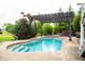Backyard pool with a dark pergola and hot tub offers a luxurious outdoor space at 4420 Hickory Ridge Blvd, Greenwood, IN 46143