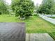 Large backyard featuring a decorative rock border around a tree, with fencing and a partial view of the home at 5130 Navajo Ct, Columbus, IN 47203