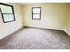 Bright bedroom featuring neutral carpeting, light-colored walls, and dark framed windows at 5130 Navajo Ct, Columbus, IN 47203