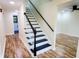 Interior staircase with white risers and black treads with a wood handrail at 5130 Navajo Ct, Columbus, IN 47203