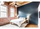 Charming bedroom features exposed brick walls, large windows, and a cozy, comfortable bed at 55 S Harding St # 308, Indianapolis, IN 46222