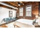 Spacious bedroom features exposed brick walls, large windows, and industrial-style elements at 55 S Harding St # 308, Indianapolis, IN 46222
