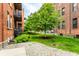 Brick building exterior with well-maintained lawn, walkways, and mature trees at 55 S Harding St # 308, Indianapolis, IN 46222