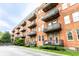 Red brick apartment building with charming balconies and well-maintained grassy landscaping at 55 S Harding St # 308, Indianapolis, IN 46222