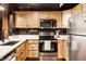 Well-lit kitchen with stainless steel appliances and wooden cabinetry offering ample storage space at 55 S Harding St # 308, Indianapolis, IN 46222