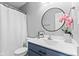 This bathroom features a round mirror, modern vanity, and shower-tub combination at 5848 Sheffield Ln, Whitestown, IN 46075