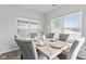 Dining area featuring a marble top table, six upholstered chairs, and multiple windows for natural light at 5848 Sheffield Ln, Whitestown, IN 46075