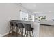 Kitchen bar with granite countertop, seating, and view into the open concept living room at 5848 Sheffield Ln, Whitestown, IN 46075